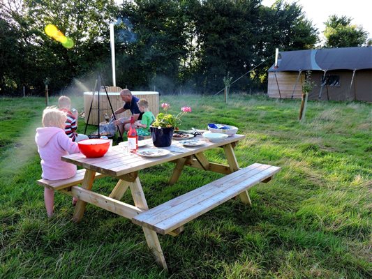 family having barbecue glamping